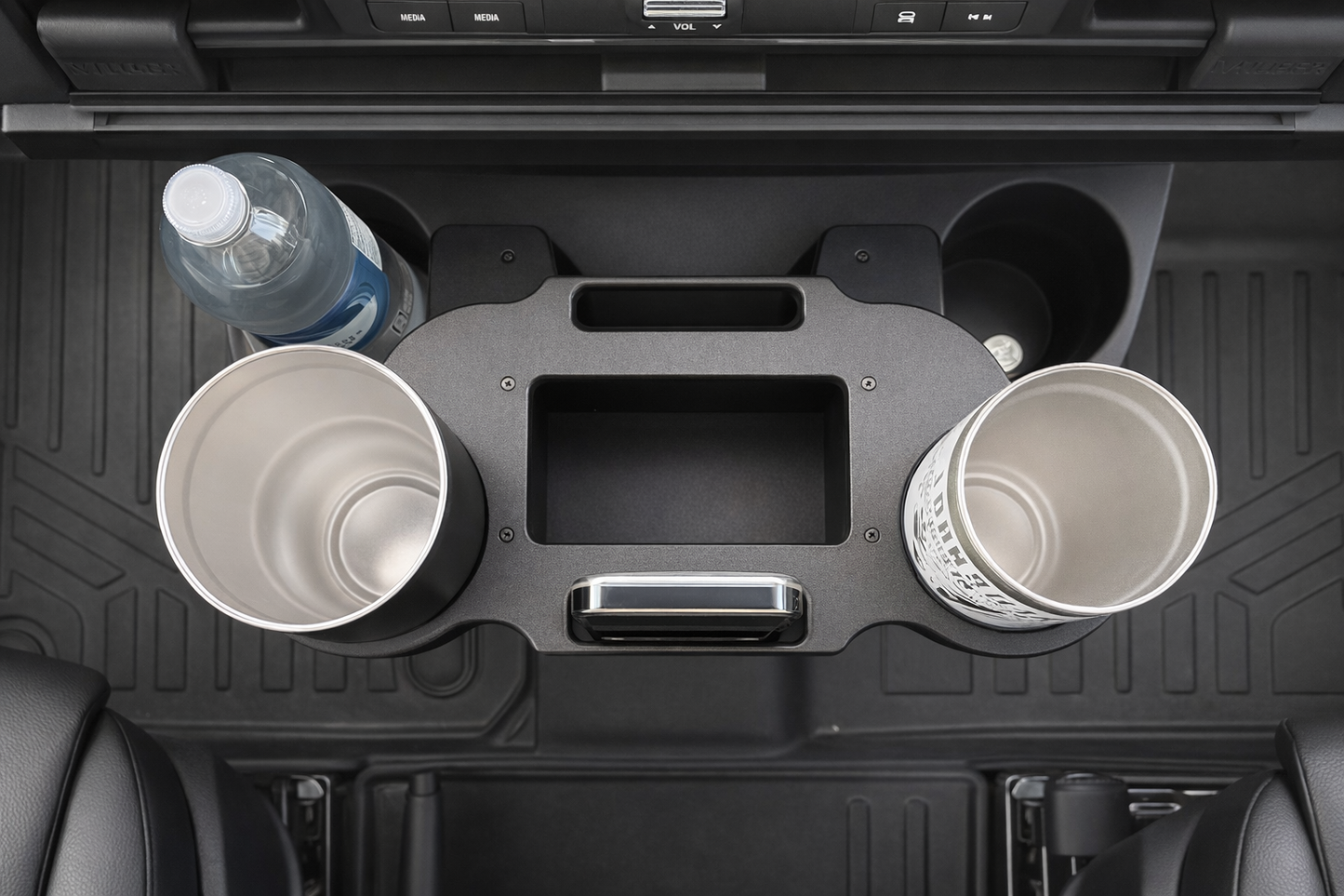 GripTurf Dash Port installed in the Mercedes Sprinter EKKO holding two travel mugs and a phone for organized front‑cab storage.