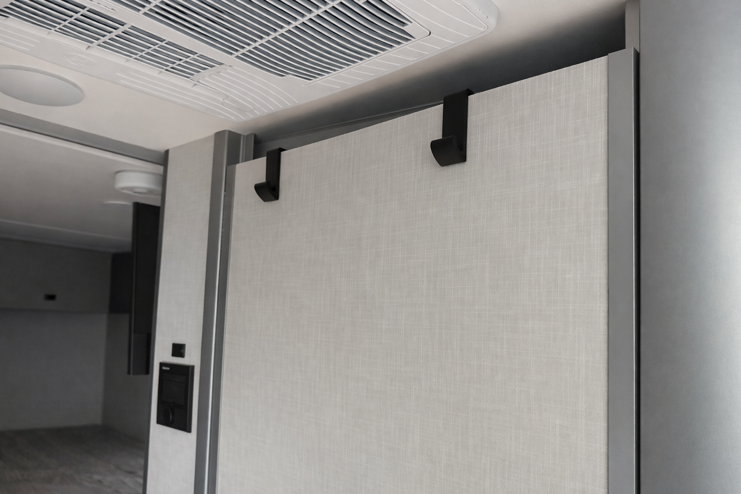 GripTurf EKKO Over‑Door Hook 2‑Pack in black mounted on the Winnebago EKKO bathroom door.