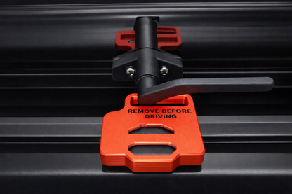Red “Remove Before Driving” EKKO window stay installed on RV window frame for secure hold‑open use
