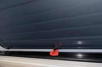 Red ASA EKKO window stay installed on Winnebago EKKO window frame holding the swing window open for ventilation